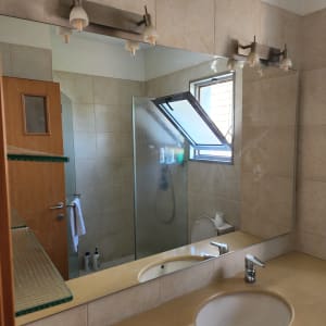 מראה גדולה מעל כיור בחדר אמבטיה