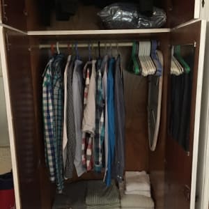 ארון בגדים עם חולצות תלויות ומגבות מקופלות
