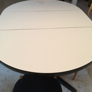 שולחן עגול עם כיסאות עץ מסביב