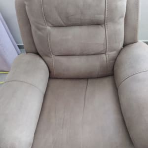 כורסה אפורה עם כתמים קלים על המושב