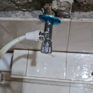 ברז מתכת עם צינור מחובר לקיר