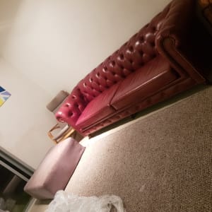 ספה אדומה עם ריפוד כפתורים על שטיח חום