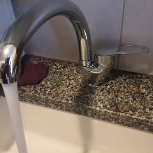 ברז מים זורמים בכיור מטבח עם ניקוז