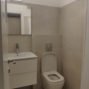 שירותים משופצים עם כיור תלוי ואסלה מודרנית