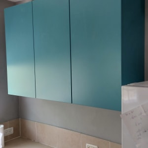 ארונות מטבח כחולים מעל משטח עבודה בהיר