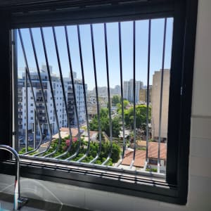 חלון עם סורגים מתכתיים נוף עירוני ברקע