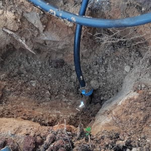 צינור שחור באדמה עם חיבור כחול