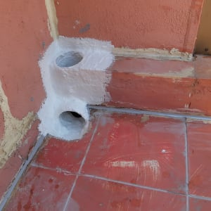 צינורות אטומים בחומר לבן על קיר ורצפה