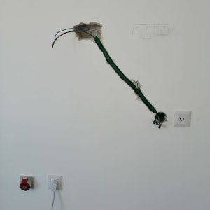 חוטי חשמל יוצאים מקיר עם שקע חשמלי