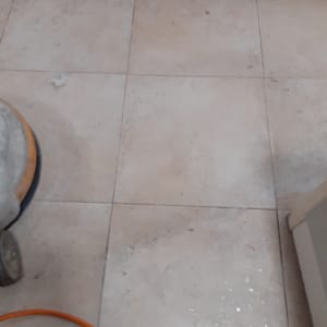 מכונת ניקוי רצפה עם כבל כתום על אריחים