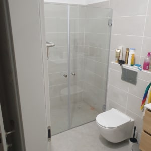 מקלחון זכוכית עם דלתות שקופות בחדר אמבטיה