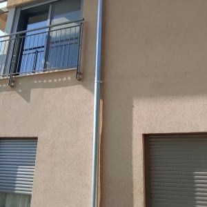 צינור ניקוז מתכת מחובר לקיר בניין