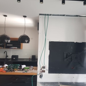 קיר לבן עם חוטים ירוקים, כלי עבודה על שולחן