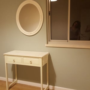 קיר צבוע בצבע ירוק בהיר עם מראה עגולה