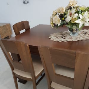 שולחן עץ עם כיסאות מרופדים בבד בהיר