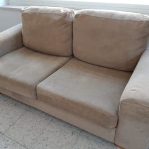 ספה חומה עם כריות על רצפת אריחים