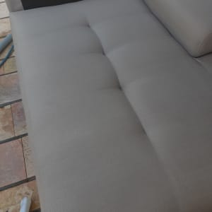 ספה אפורה עם צינור ניקוי על הרצפה