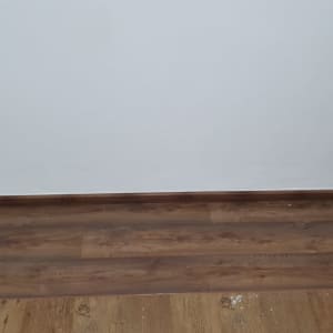 רצפת פרקט עץ כהה עם קיר לבן