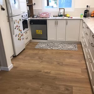 רצפת פרקט עץ במטבח ביתי עם ארונות לבנים