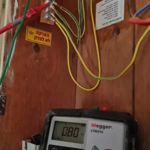 מד מתח חשמלי מחובר לחוטים צבעוניים