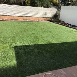 דשא סינתטי עם גבול אדמה ואבנים בגינה