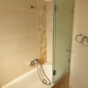 אמבטיה עם דלת זכוכית וברז מקלחת