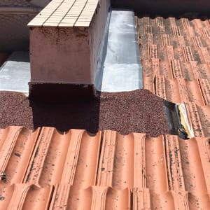 רעפים כתומים על גג עם חיפוי מתכת ואיטום