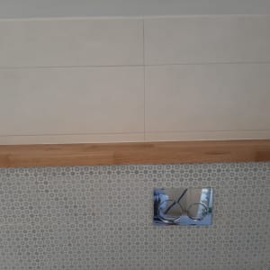 מדף עץ מותקן על קיר אריחים