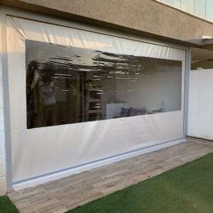 סוכך לבן עם חלון שקוף מותקן על קיר חיצוני