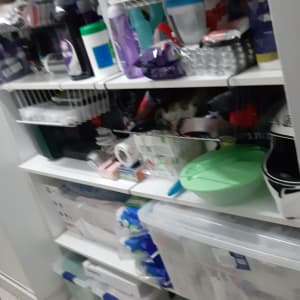 מדפים עם מוצרי ניקוי, קופסאות פלסטיק ומכסים