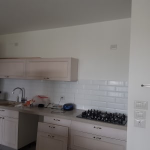 מטבח עם ארונות, כיור וכיריים על הקיר