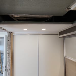 תקרת גבס עם תאורה שקועה ותעלות מיזוג חשופות