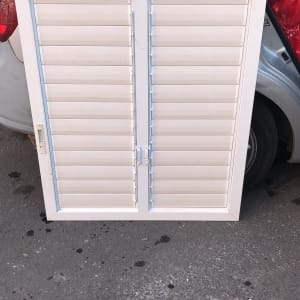 תריסים לבנים עם מסגרת על רקע רכב