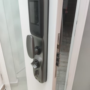 מנעול דיגיטלי על דלת לבנה עם ידית וכפתור