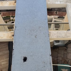 משטח איטום עם חורים ושכבת זפת על גג