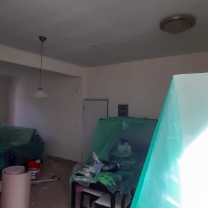 חדר עם רהיטים מכוסים בניילון, ציוד צביעה על שולחן