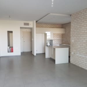 מטבח נקי עם רצפה מבריקה וקירות לבנים