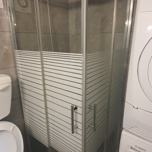 מקלחון זכוכית עם דלתות מתכת וראש מקלחת