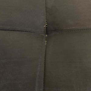 תפרים על ריפוד כהה עם רוכסן קטן