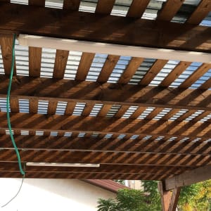 פרגולה מעץ עם גג פלסטיק שקוף וטפטפות ירוקות