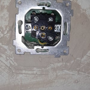 שקע חשמלי פתוח עם חוטים חשופים בקיר