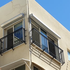 מרפסות עם מסגרות מתכת שחורות על קיר בניין