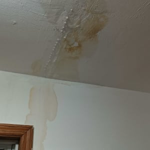 כתמי רטיבות על תקרה וקיר ליד חלון