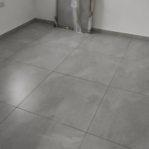 רצפה נקייה עם אריחים אפורים בחדר ריק