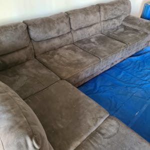 ספה אפורה עם כיסוי כחול על הרצפה