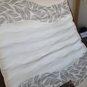 מזרן עם דוגמת עלים אפורה על רקע לבן