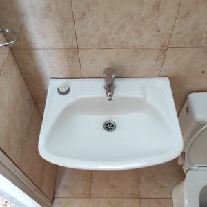 כיור לבן עם ברז וכפתור סבון