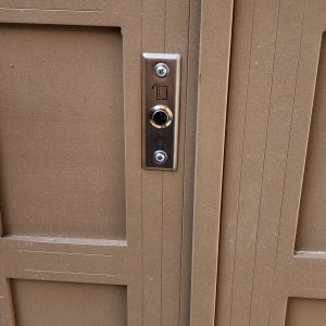 לחצן אינטרקום על דלת מתכת חומה