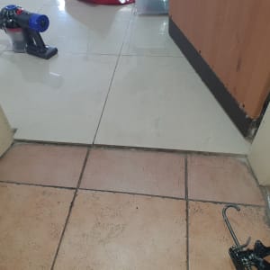 שואב אבק ידני על רצפה ליד דלת פתוחה