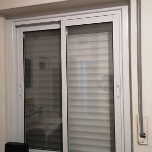 חלון אלומיניום עם תריסים לבנים